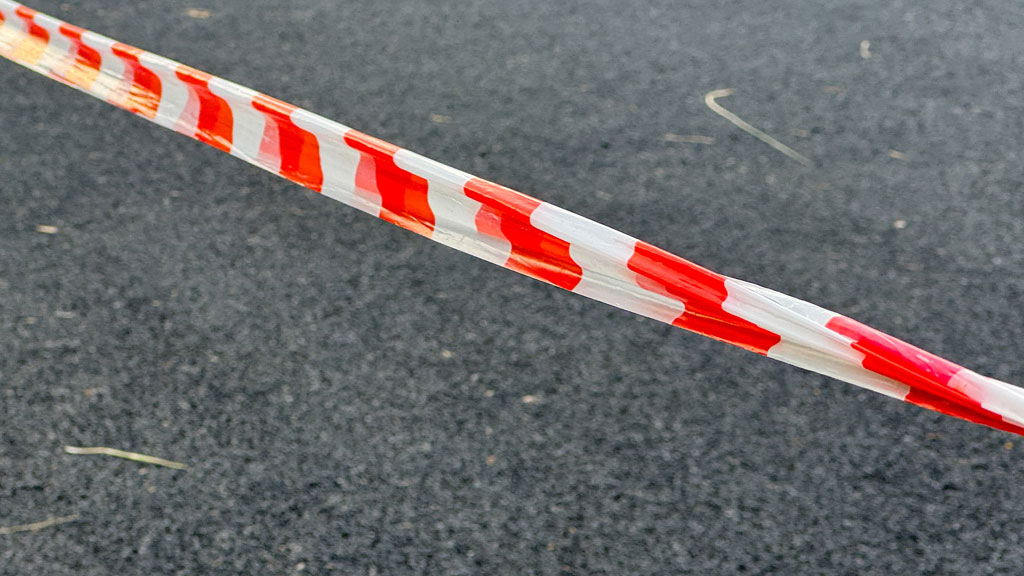 Barrière extensible orange déployée autour d'une zone de maintenance dans une installation industrielle